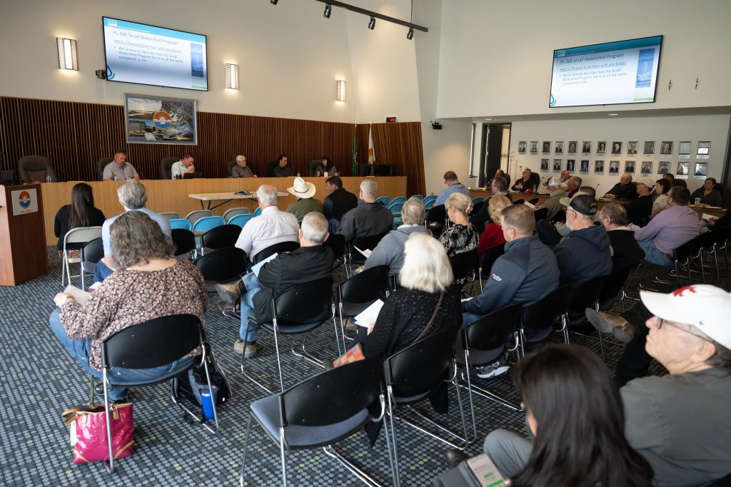 board room full of attendees and speakers